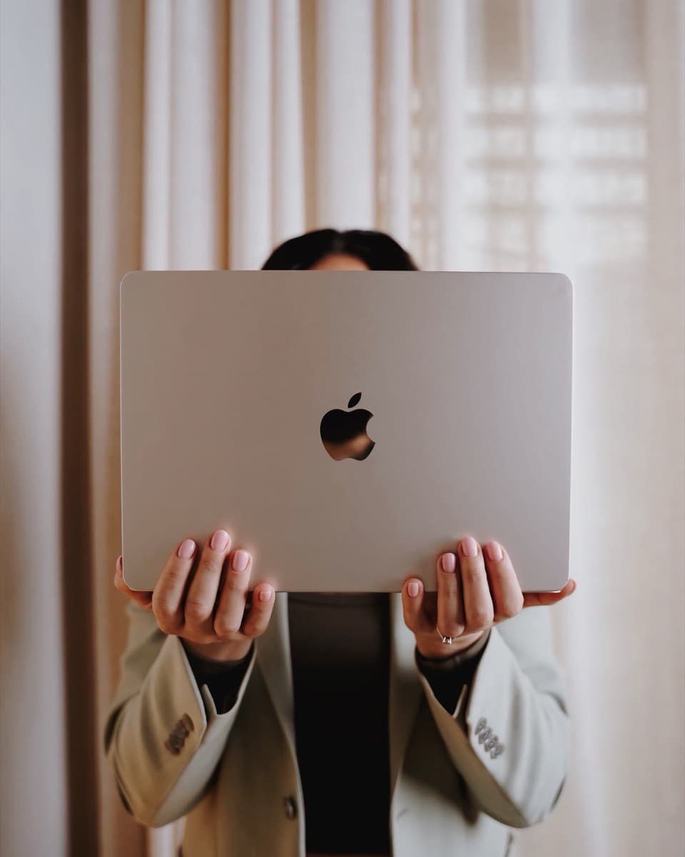 Amalin holding a laptop up in front of the camera