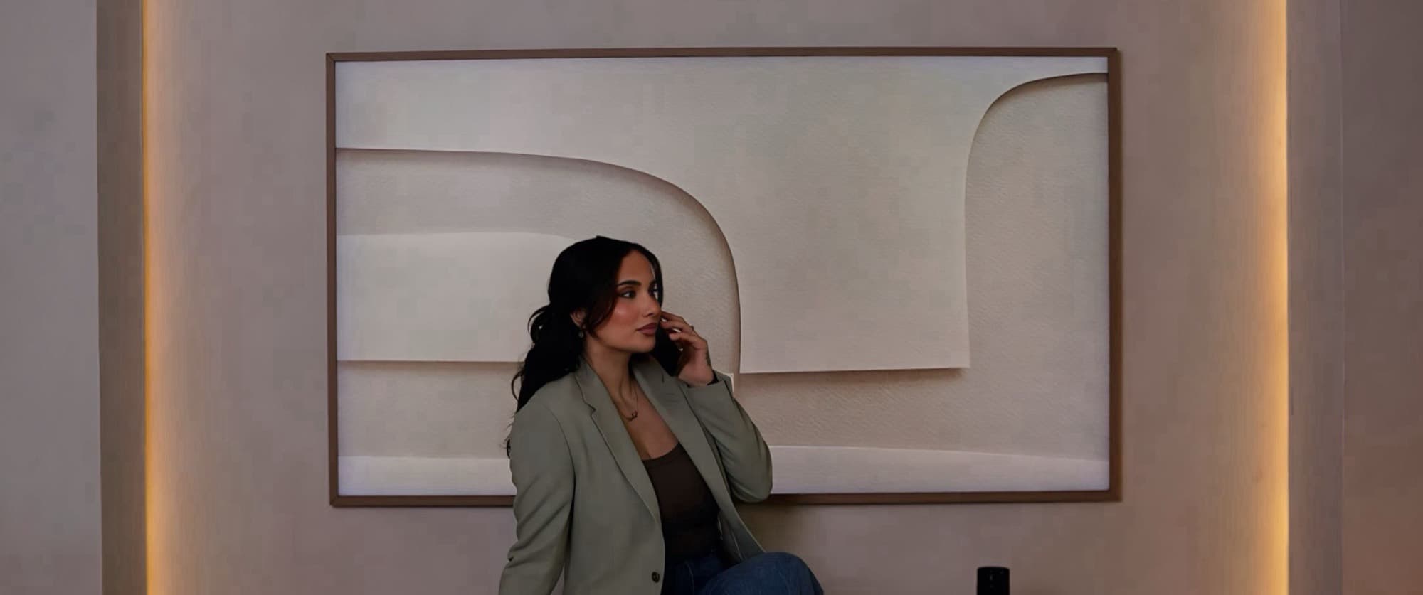 Amalin on the phone in a lit arched alcove